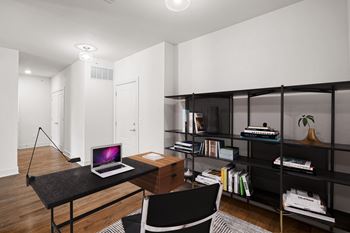 A black desk with a laptop on it in a room. at Mirabelle Luxury Apartments, Kansas City, MO, 64111